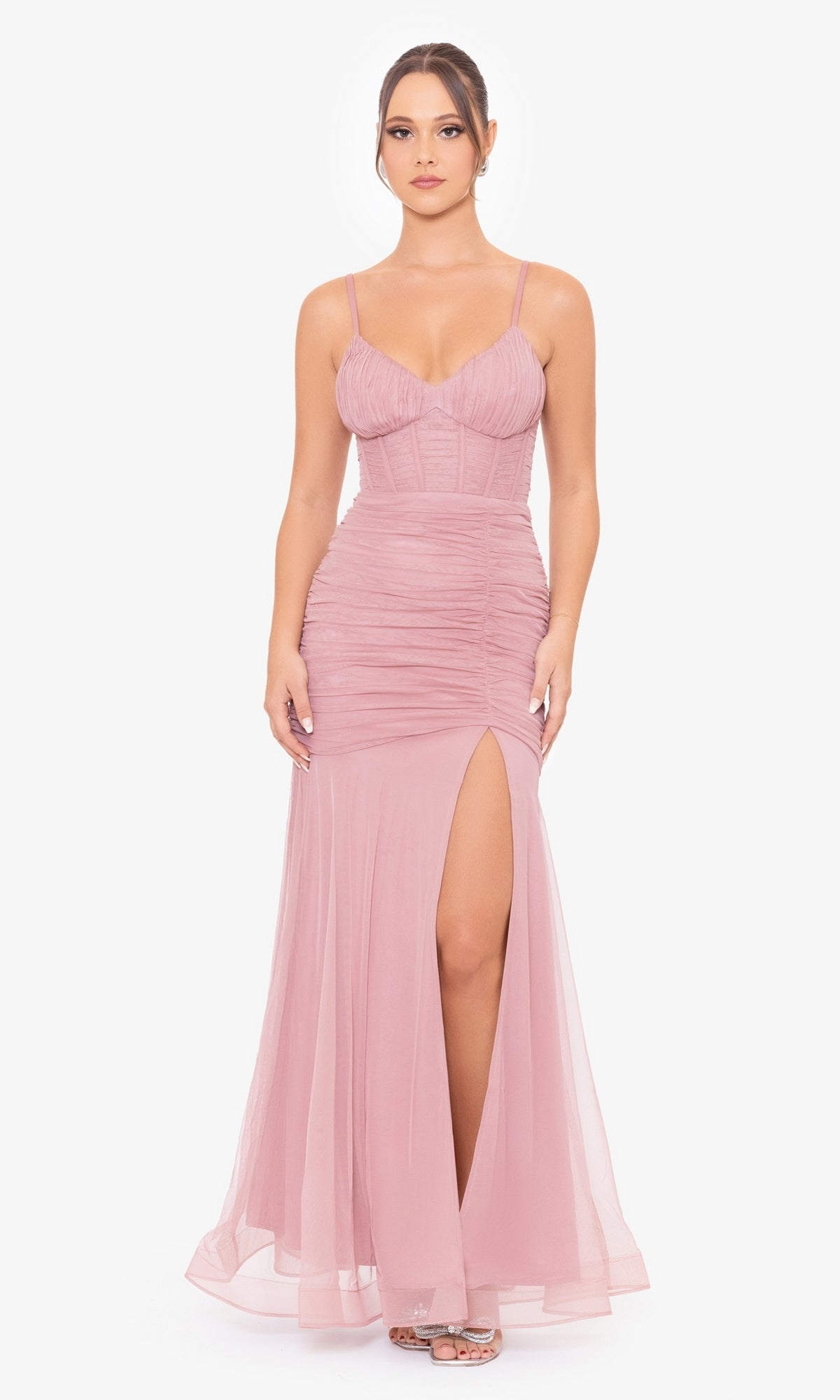 A woman models the Corset-Bodice Long Mermaid Prom Dress 4682BN in rose, featuring a sleeveless fitted corset bodice, ruched detailing, and a thigh-high slit, standing against a plain white background.